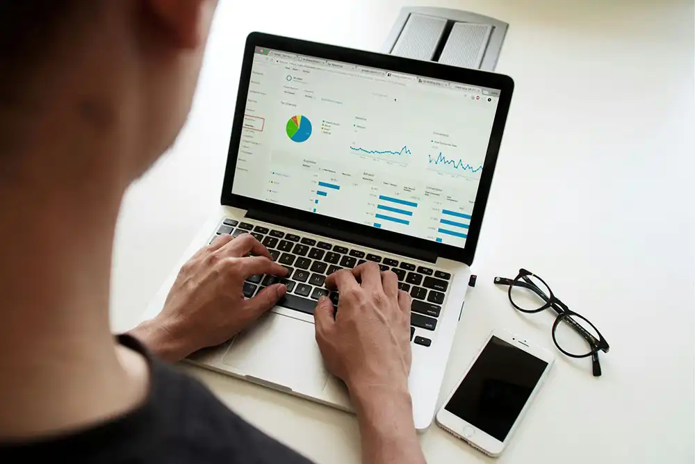 A worker studying SEO analytics on an Apple laptop.