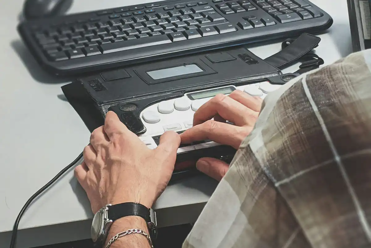 a blind user operating a refreshable braille display and keyboard
